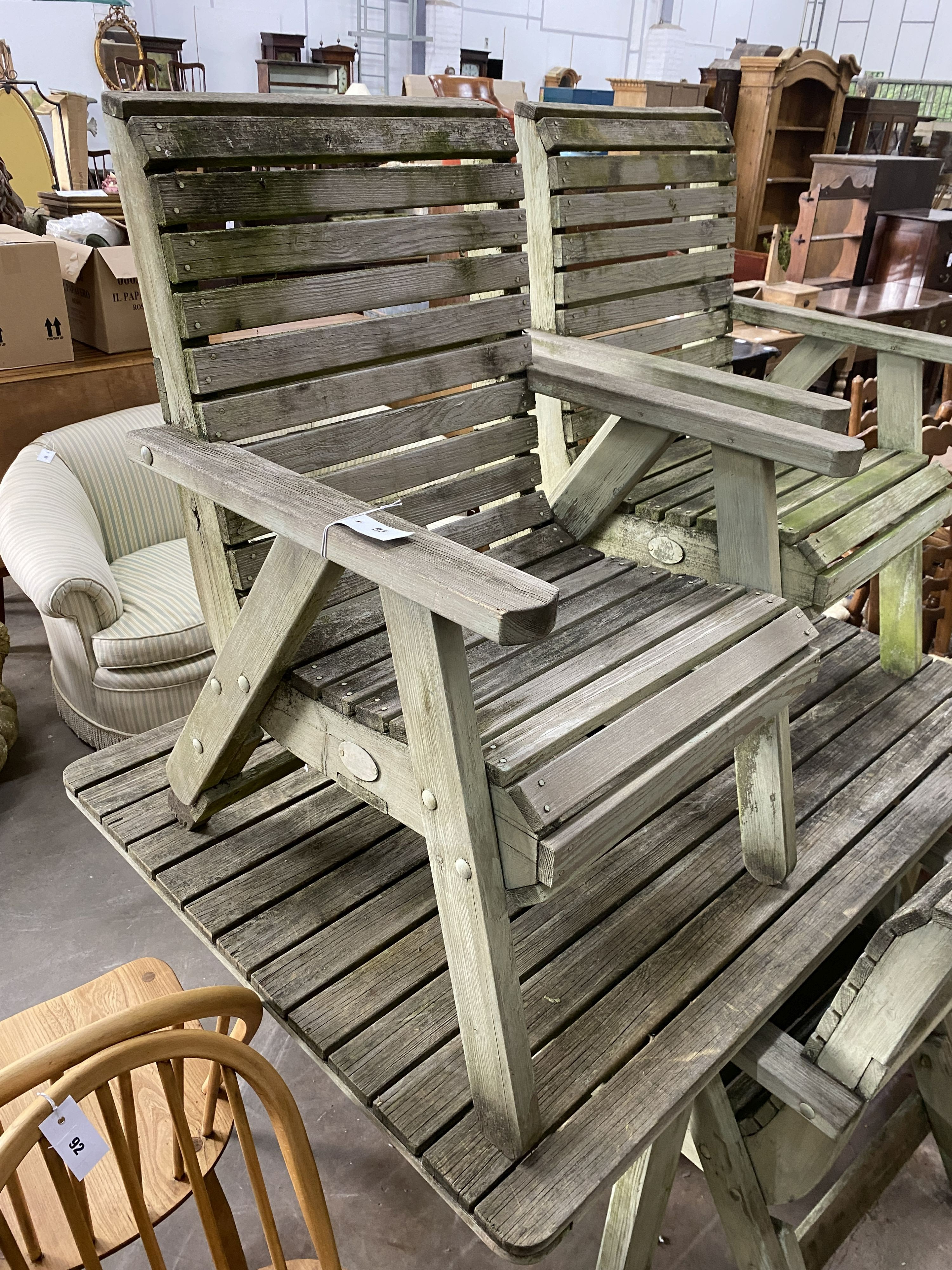 A weathered teak rectangular slatted garden table, length 145cm, depth 100cm, height 70cm and four weathered teak elbow chairs